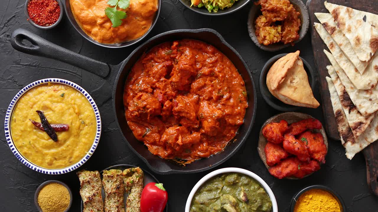 varios platos indios en una mesa pollo picante tikka masala en sartén de hierro