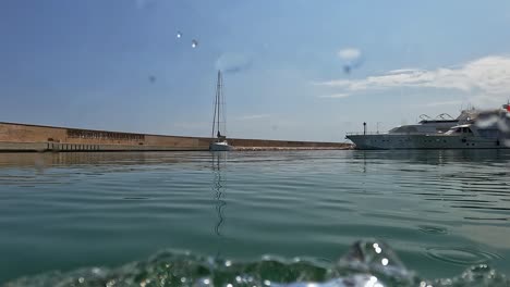 First-person-low-angle-pov-of-yacht-entering-in-harbor