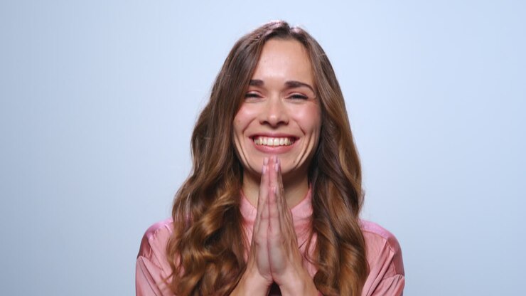 Donna d'affari felice che ride in studio. Donna sorridente che batte le mani.
