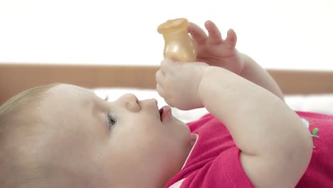 kid plays with a pacifier takes it in his mouth