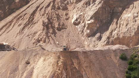 Dolly-out-of-a-mining-bulldozer-in-detail-in-a-limestone-extraction-in-the-province-of-Jujuy,-Argentina-on-a-sunny-day,-mounted-with-minerals-and-exposed-weathered-rock