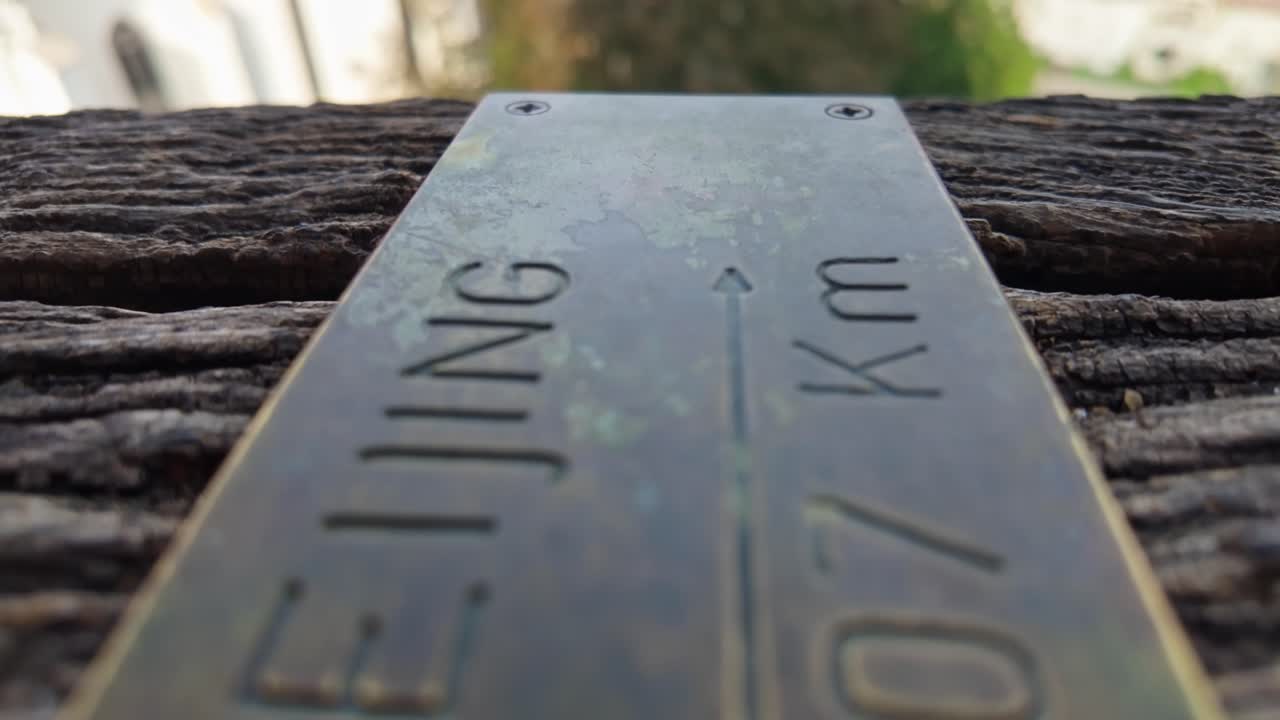 Close-up of a metal plate indicating the distance to Beijing, China from the Clock Tower in Sighișoara, Romania