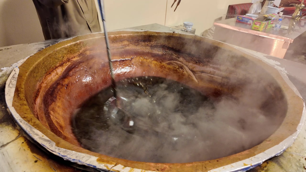 Boiling Syrup Being Stirred in a Traditional Copper Pot