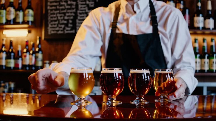 Barman che degusta diverse birre al bar