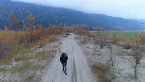 Man-playing-with-his-dog-on-dirt-track-4k