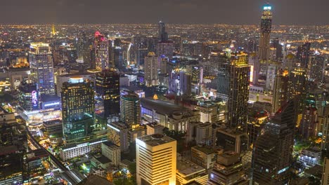 aerial view of ploenchit junction with cars traffic skyscraper buildings. bangkok city in downtown at night, thailand