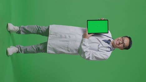 médico con la tableta en la pantalla verde