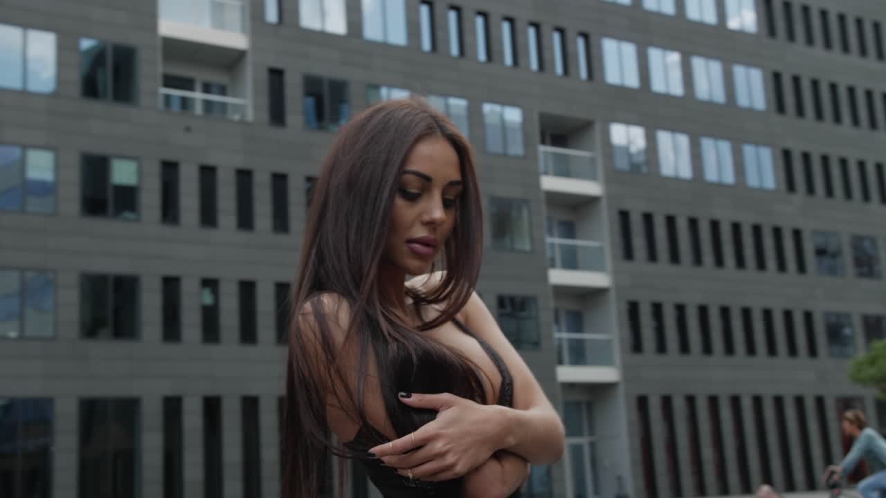 bella modelo morena posando en una ciudad