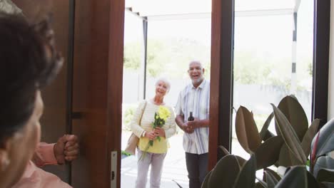 Happy-senior-biracial-couple-opening-door-at-retirement-home