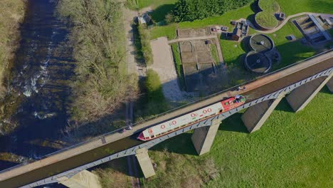 un impresionante viaducto, puente en la hermosa ubicación galesa del acueducto pontcysyllte y la famosa ruta del canal llangollen como un estrecho barco cruza
