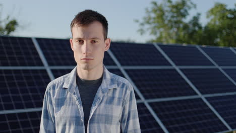 retrato de un joven contra el fondo de los paneles de la planta de energía solar