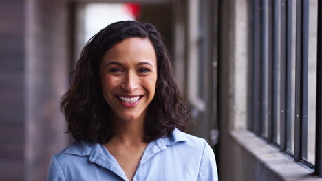 Young-mixed-race-businesswoman-turning-to-camera,-laughing