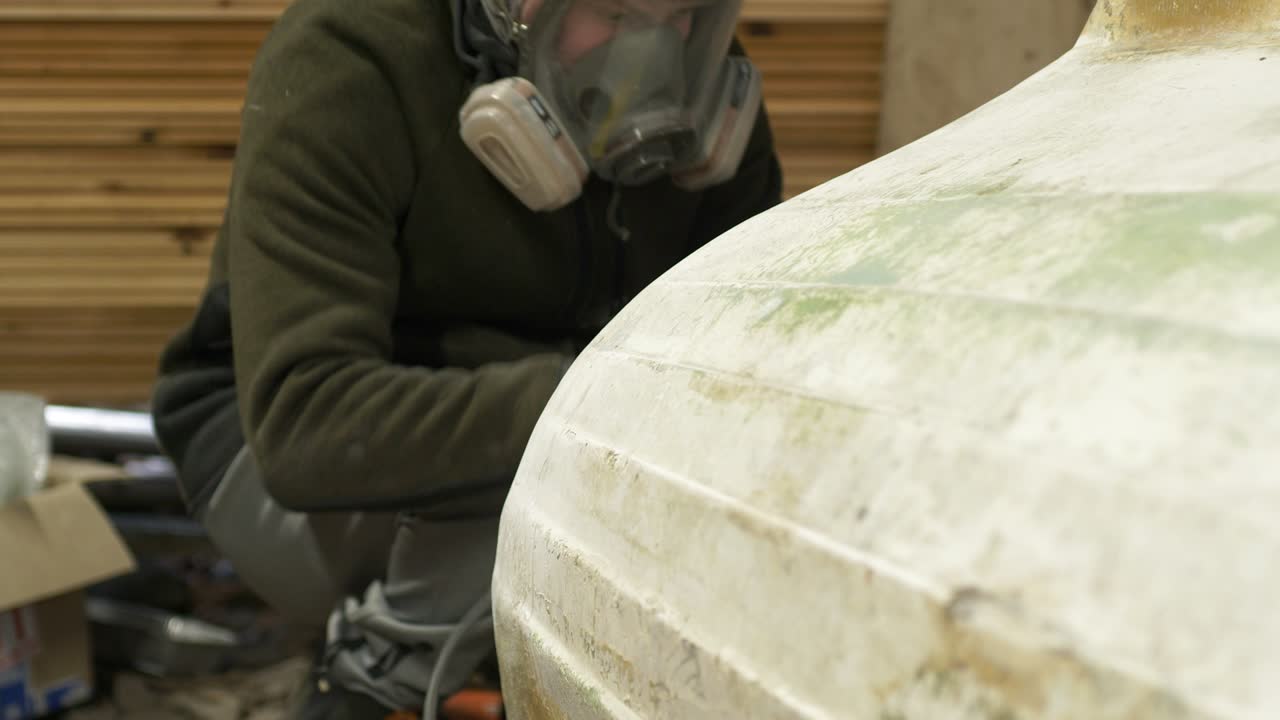 Sanding transom of fiberglass boat using electrical sander