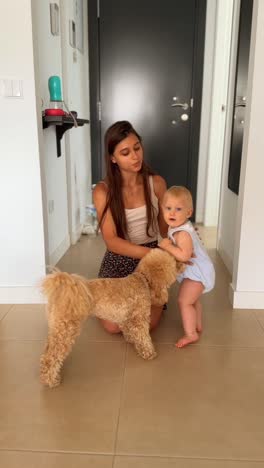 madre y bebé jugando con el perro