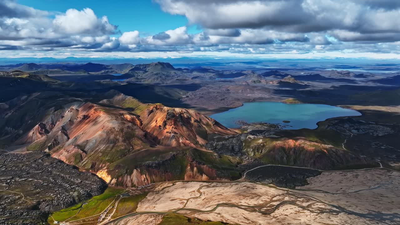 Rivers in sand, blue lake and lava field with mountains in an aerial drone view of Iceland’s highlands