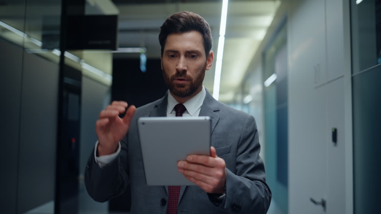 Businessman holding pad walking empty hall closeup. Shocked accountant tablet