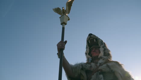 roman soldier with eagle standard and tiger head helmet