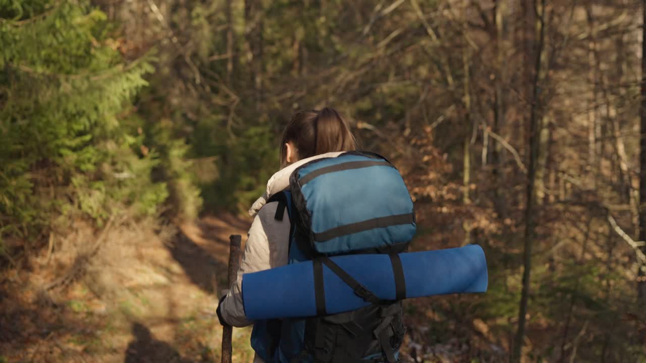 Woman hiking with backpack in the forest