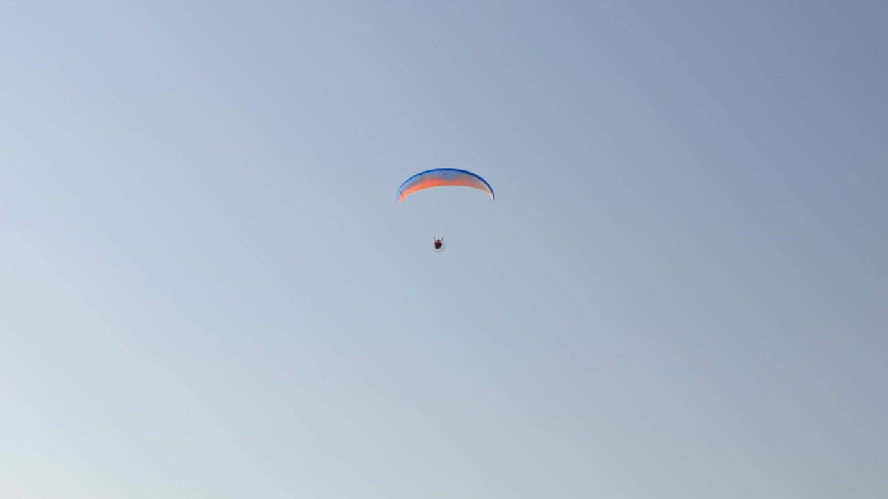 vista de un hombre volando en un planeador contra el fondo de un cielo sin nubes. grecia.