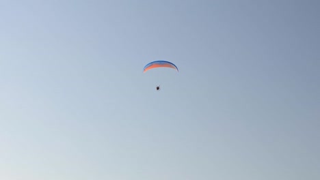 vista de un hombre volando en un planeador contra el fondo de un cielo sin nubes. grecia.