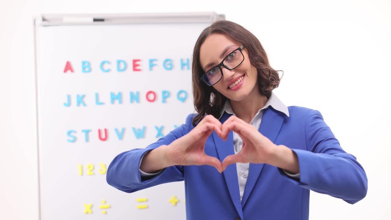 Teacher making heart gesture in classroom