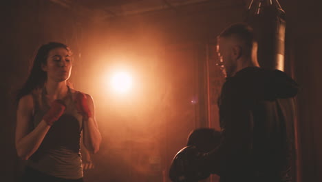 Mujer-Boxeadora-Golpea-Los-Guantes-De-Su-Entrenador-Y-Esquiva-Sus-Golpes