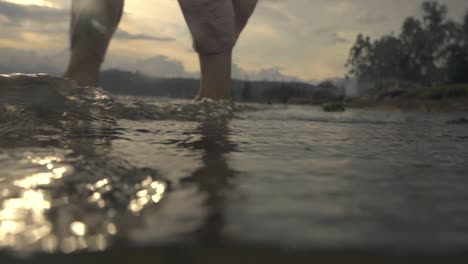 Girl-walking-into-the-lake-barefoot