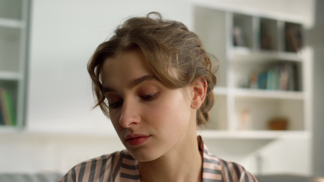 студент смотрит веб-семинар дома вблизи. серьезная девушка выглядит веб-камерой утром.