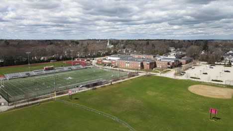 Drone-shot-over-sport-pitches-and-school-with-Boston-city-in-far-distance