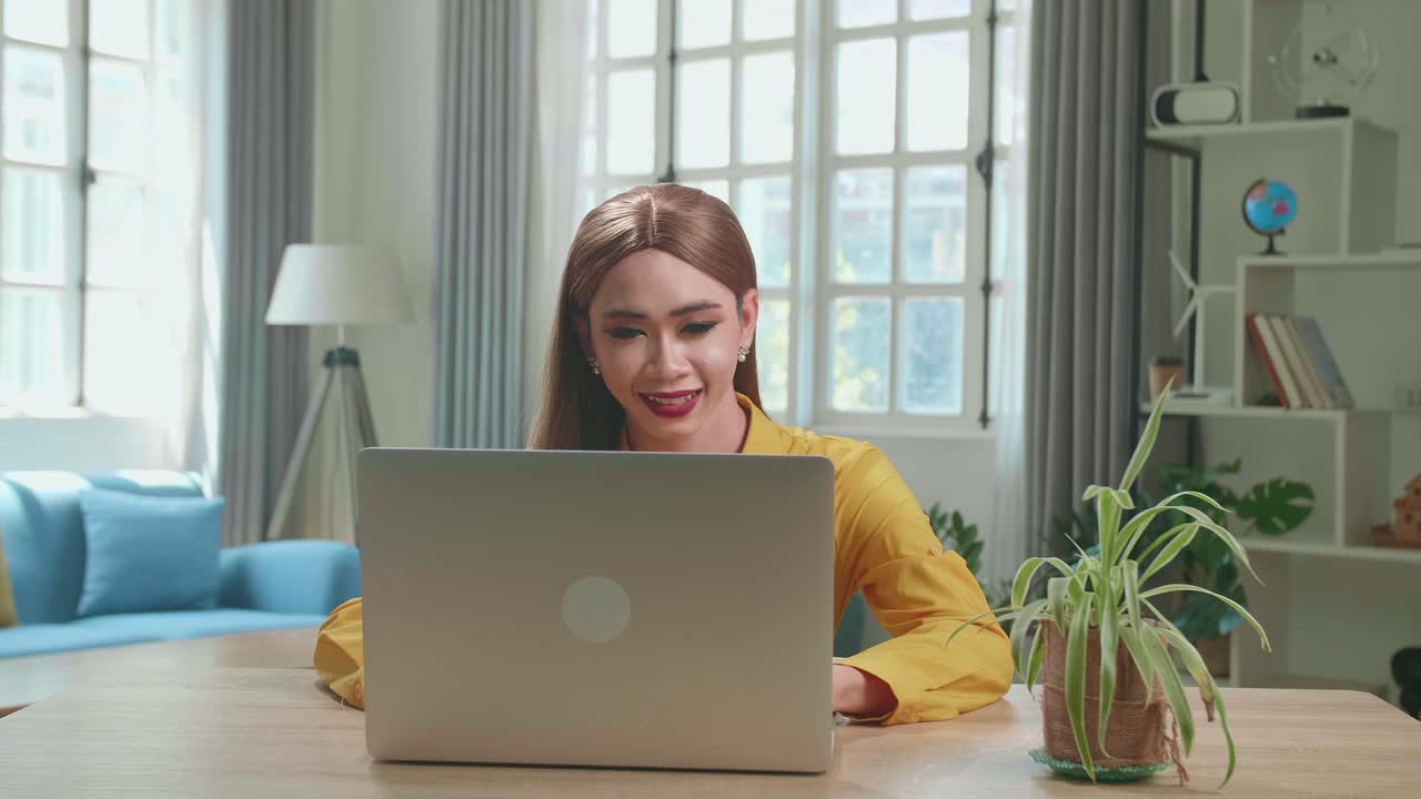 Asian Young Transgender Woman Working With Laptop Computer In Living Room