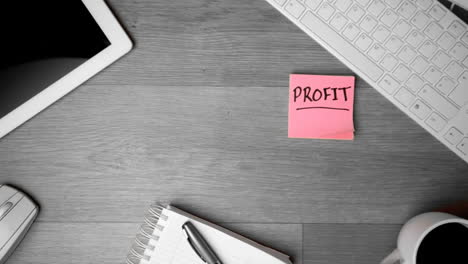 pink post its with profit written in bold falling on office desk