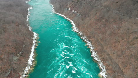 Aerial-shot-of-rapids-in-bright-teal-river