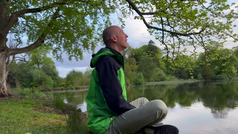 hombre calvo respirando cerca del lago