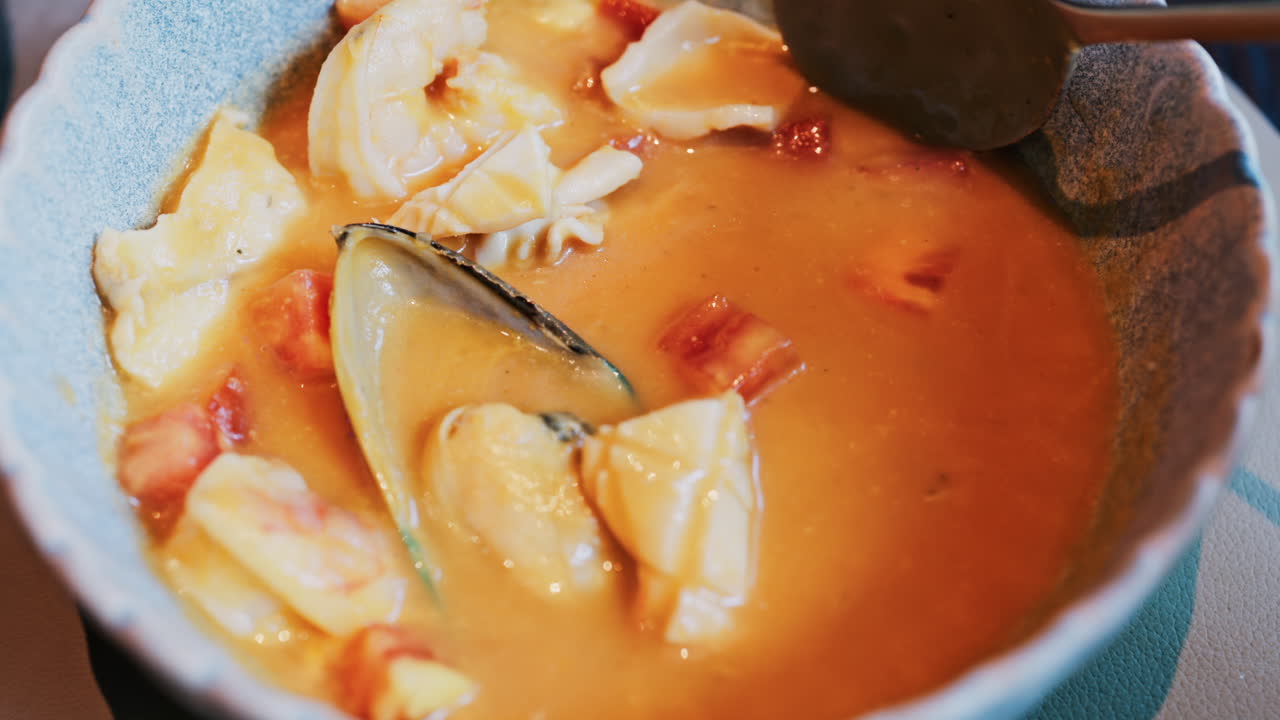 Close up of a creamy seafood stew with mussels, squid, and shrimp
