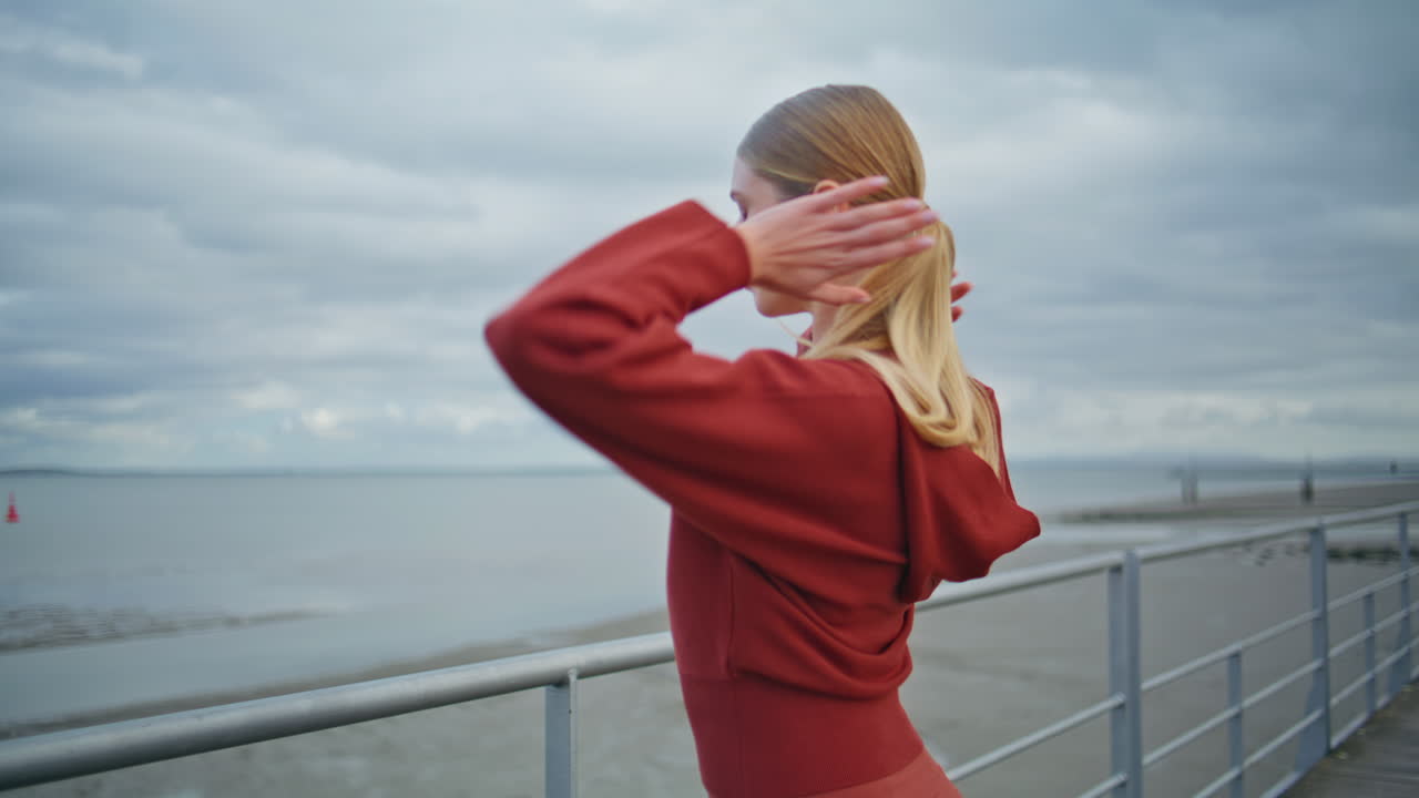 Pensive girl looking sea coast at pier. Closeup sport athlete resting at shore