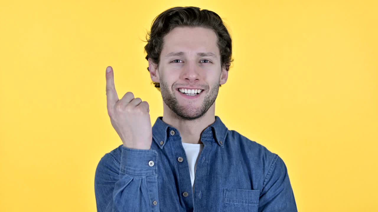 joven contemplativo pensando en una nueva idea sobre un fondo amarillo