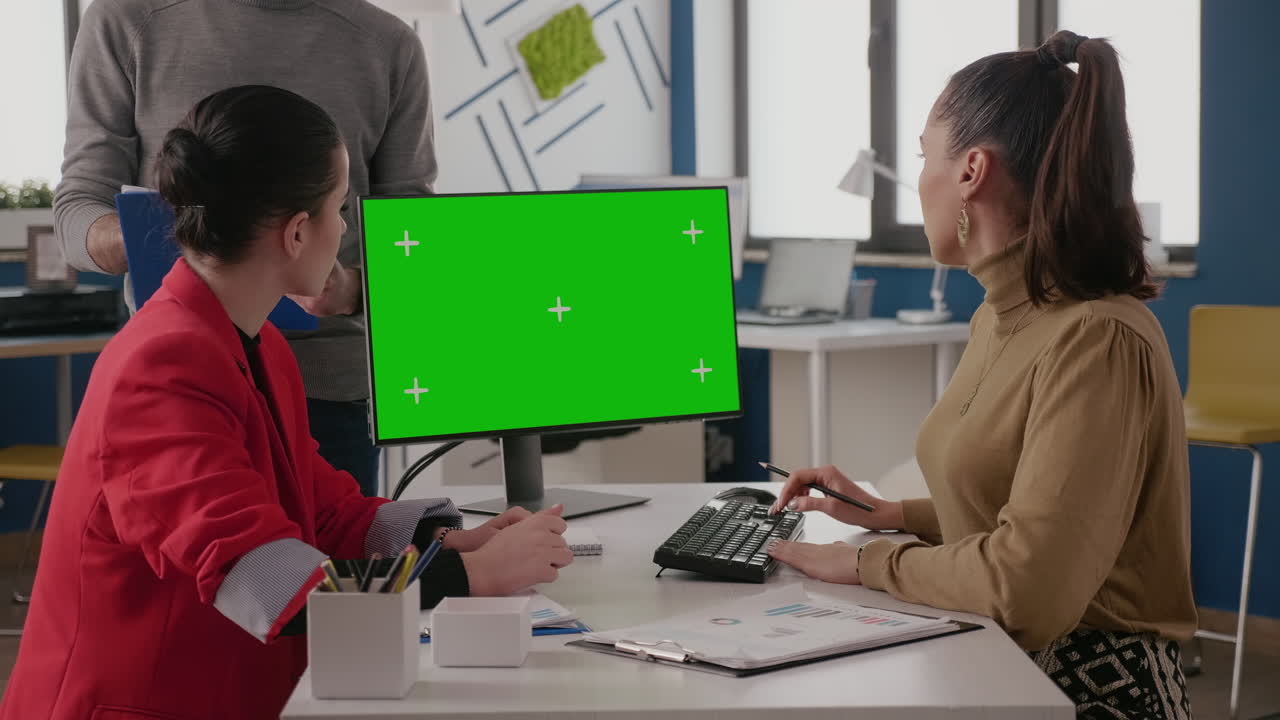 Team of colleagues working with green screen on monitor