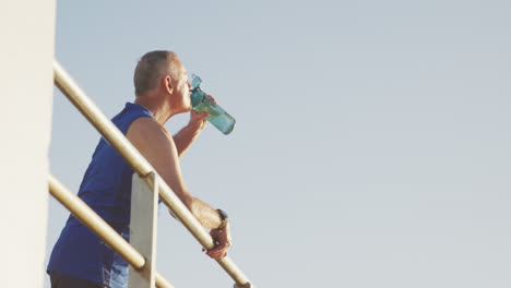 Älterer-Mann-Trinkt-Wasser-Auf-Der-Promenade