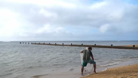 pescador con red de pesca en la playa 4k