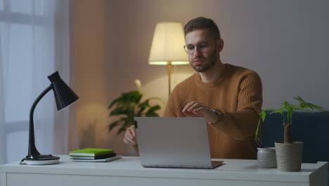 Erwachsener-Mann-Beendet-Nachts-Die-Arbeit-Mit-Laptop,-Schließt-Notebook-Und-Schaltet-Tischlampe-Aus,-Erschöpfter-Freiberufler-Und-überarbeitet