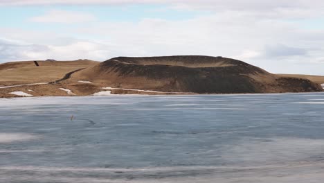 lonely volcanic crater by frozen lake near skútustaðir, mývatn in early spring light