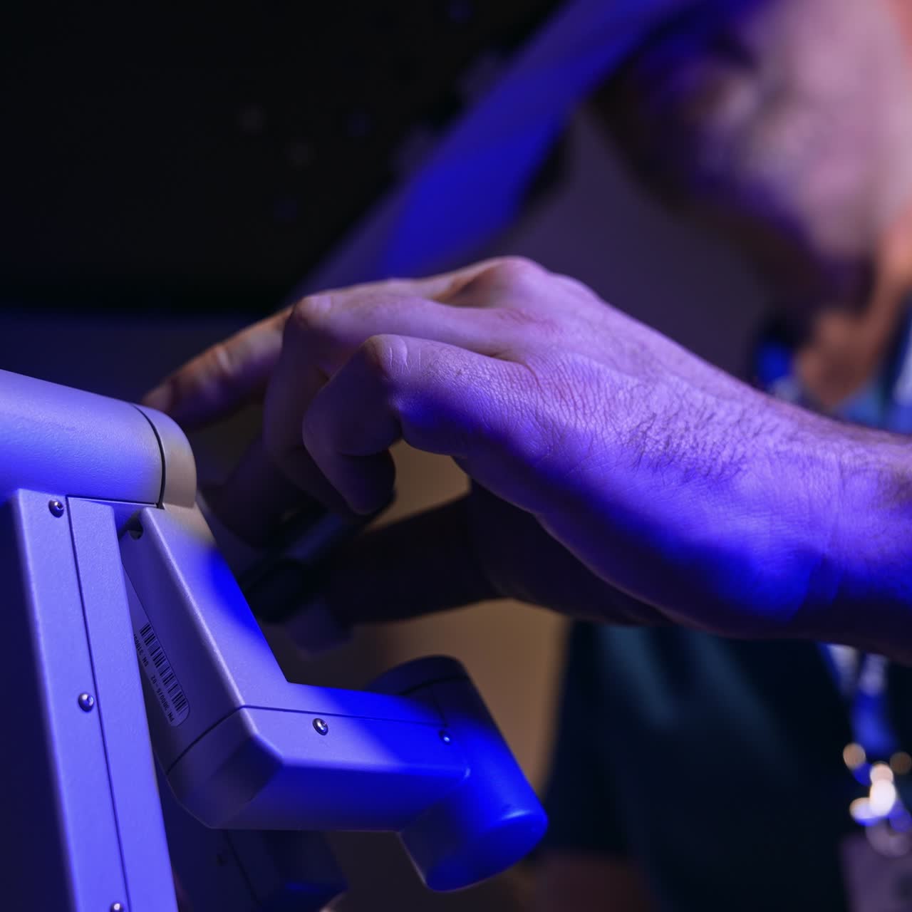 Surgery specialist operating innovative robotic equipment. Doctor looks into special binoculars and moves the handles. Close up. Low angle view