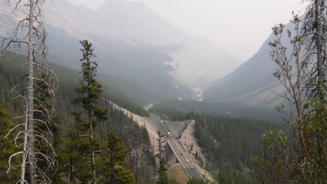 wide angle of a mountain road winding through smoky mountain scenery in 4k