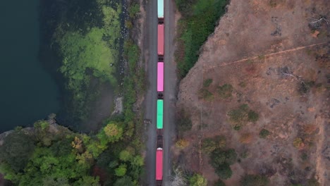 top down view of train cars running alongside a river