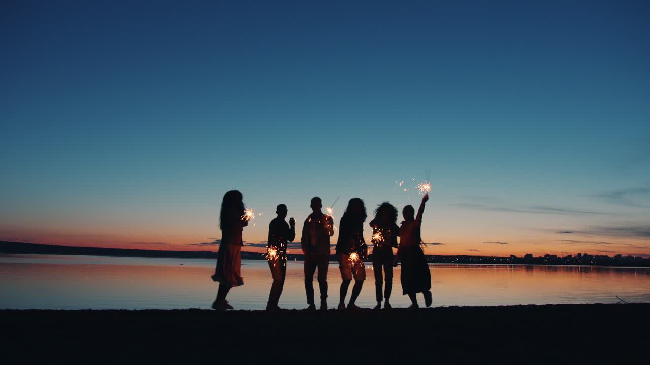 Friends Celebrating Sunset on the Beach with Sparkler