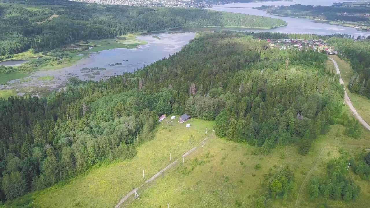 Luftfoto af et skovlandskab med en flod og en landsby