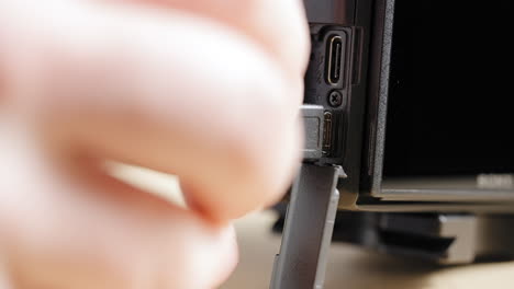 Close-up,-person's-hand-opening-camera-port-cover-connecting-micro-usb-to-charge-DSLR