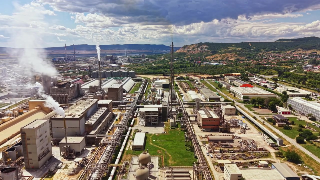 Factory complex in an industrial area with production facilities and machinery under a cloudy sky in a daytime setting