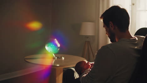 a father holding his newborn baby in soft, sunlit moments