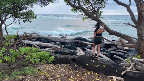 woman looking out at the ocean while camera pans in from behind her